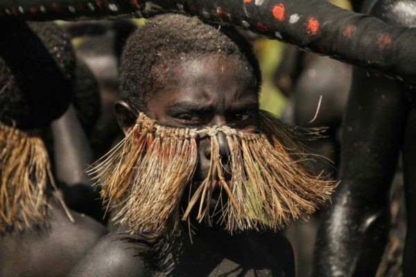 Goroka, 2014. Known as the ‘snake dancers’, young boys are painted completely black and carry a large pretend snake as part of their traditional singsing.