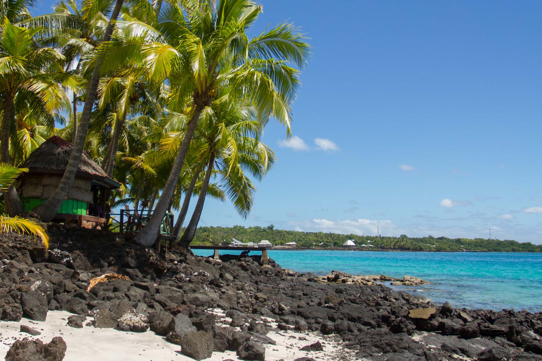 Traditional Samoan beach fales hug the coastline