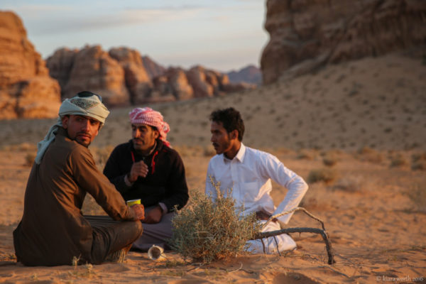 The Bedouin guides enjoy a cup of tea in the desert.