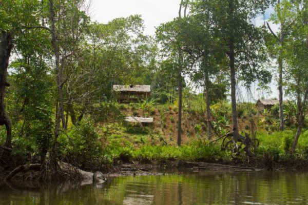 As we turn a bend in a river we come across a secluded village on the waters edge.