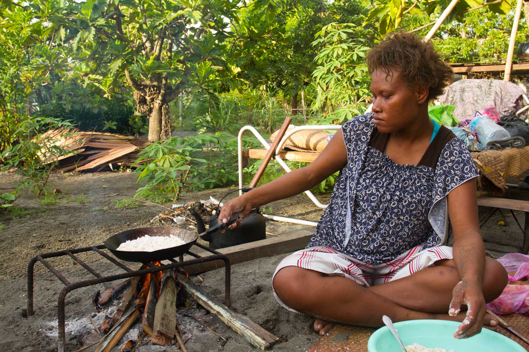 A woman makes coconut sago on a wood fire.