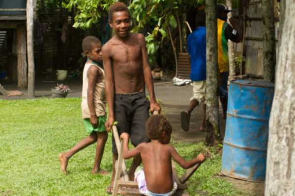 Local innovation: these boys have made a push-cart of sorts from scrap planks of wood and an old buoy.