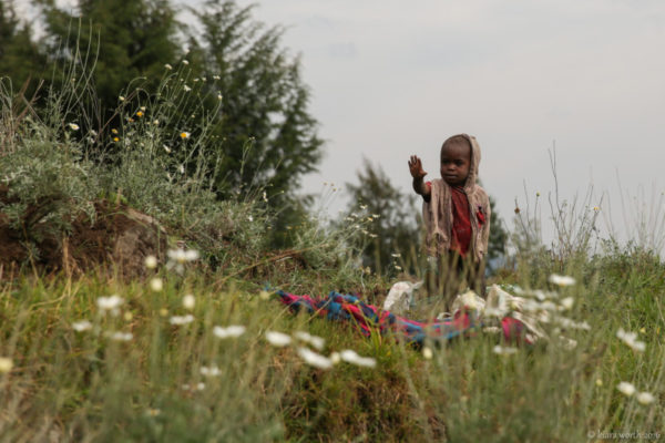 A young boy greets us as we walk past the fields