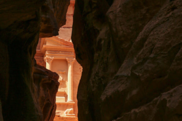 The first sliver of the Treasury, Petra’s most famous site, can be seen between a thin gap in the rocks.