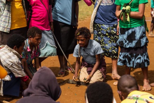 Para, Hela Province, 2014. School children play a game of marbles during a break from class.