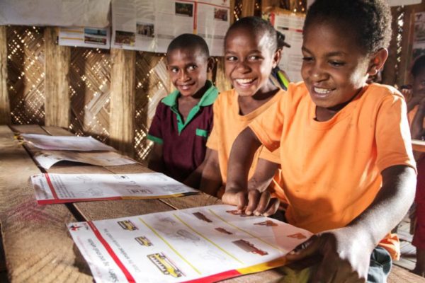 Homa, Southern Highlands, 2013. In a newly constructed learning centre built by the Homa Marupa Women’s Youth Group, children huddle around a table to learn about the importance of road safety.