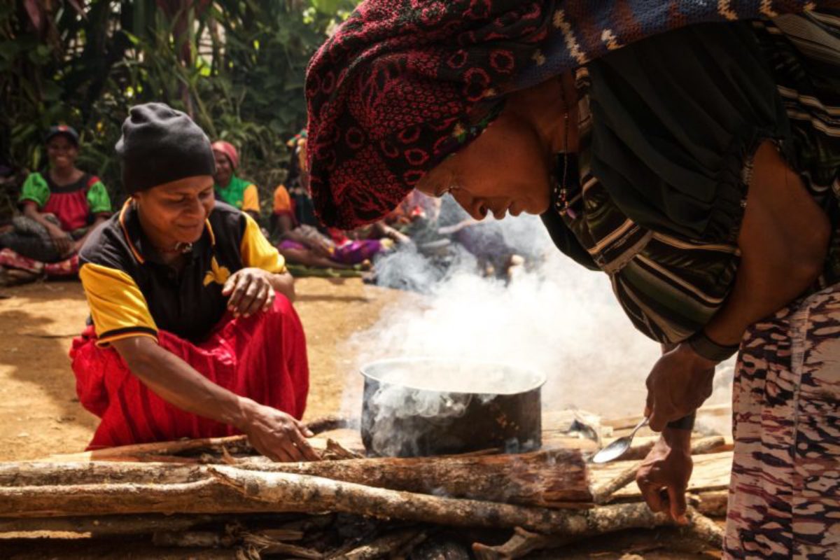 Katopa, Hela Province, 2013. Women stoke the fires to produce their ‘one pot’ meal – a meal of grains, vegetables and protein that meets their nutritional requirements.