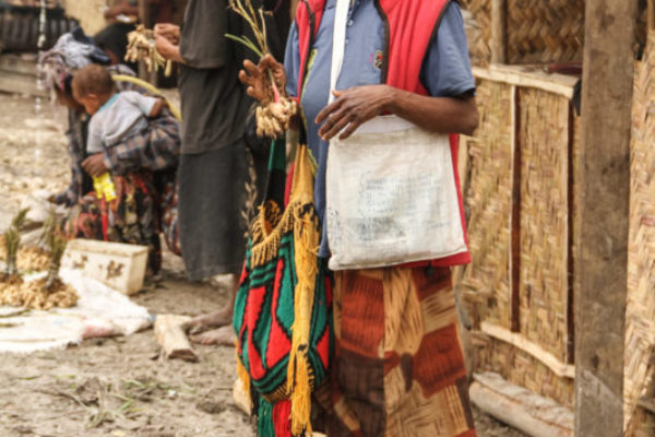 Mendi, Southern Highlands Province, 2012. At an informal market outside of Mendi, a woman sells peanuts to people starting their journey along the Highlands Highway