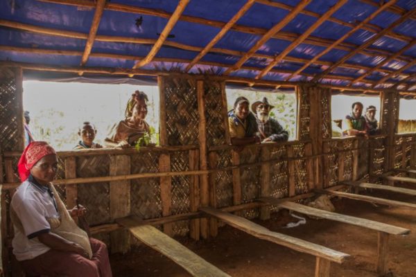 Angore, Hela Province, 2013. Villagers peer in through the windows or a newly built community centre.