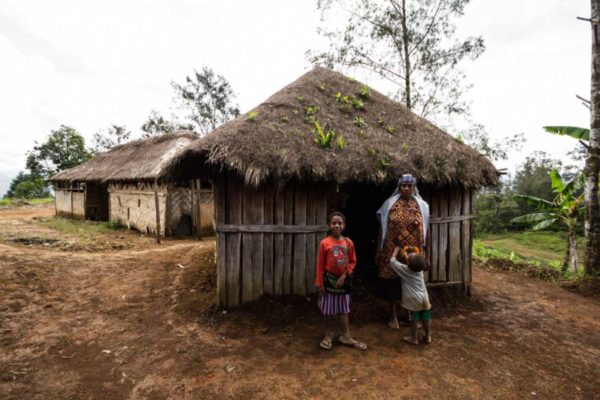 Mabuli, Hela Province, 2014. Tai Himu stands in front of a hut that she uses as a birthing clinic in her village of Mabuli. With little access to medical facilities and with only basic training herself, Tai has helped birth more than 100 babies from around the area.