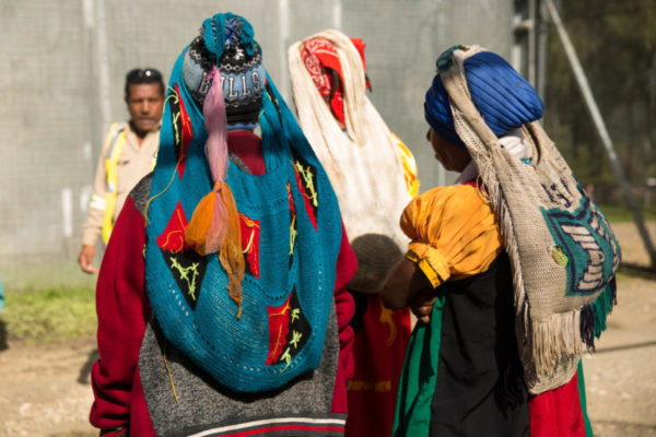 Hides, Hela Province, 2018. Women wear their traditional bilums, a woven bag delicately balanced on their heads.